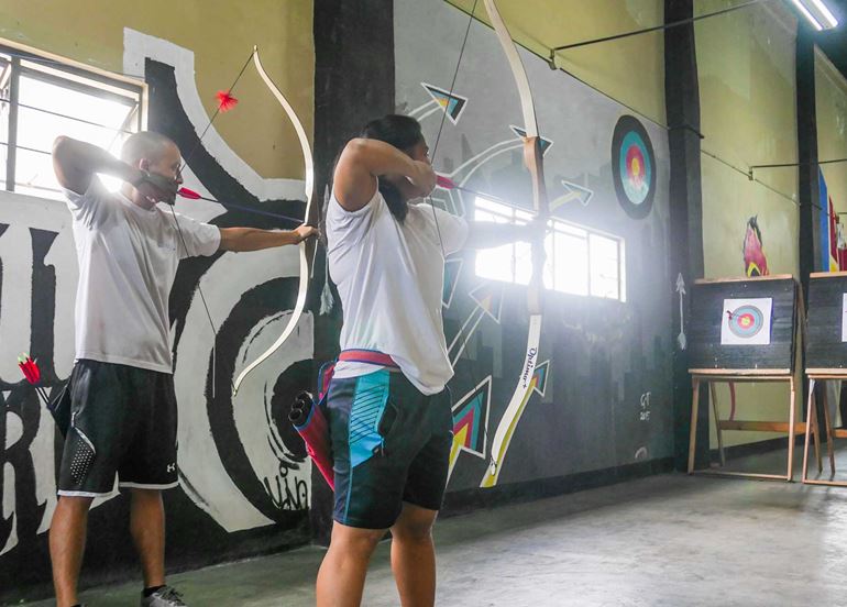 couple-aiming-bow-and-arrows