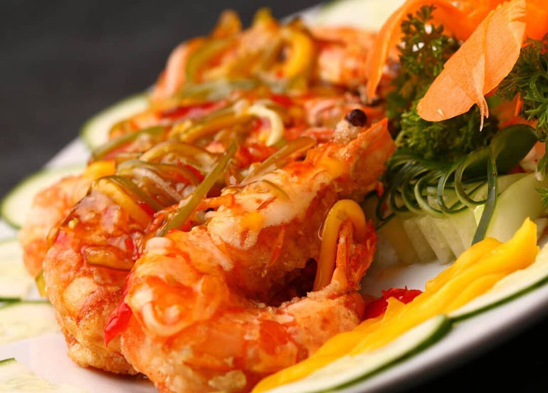 cooked shrimp garnished with carrots, cucumber, and parsley