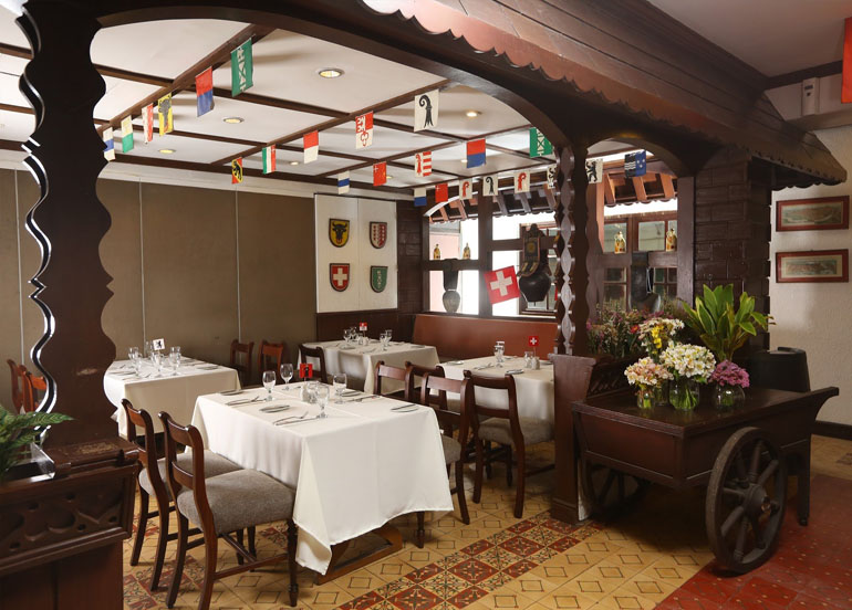 Old Swiss Inn Interior with flags hanging from the ceiling