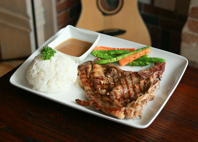 Rustic Box T-Bone Steak with a side of veggies, gravy and rice